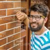 Smiling Young Man Leaning On Wall Stock Photo