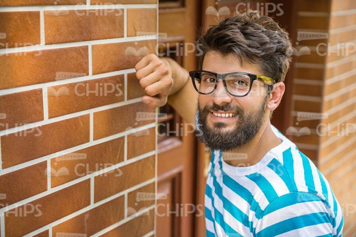 Smiling Young Man Leaning On Wall Stock Photo