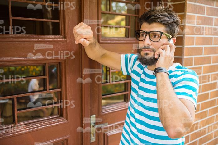 Serious Bearded Man Talking On Mobile Phone Stock Photo
