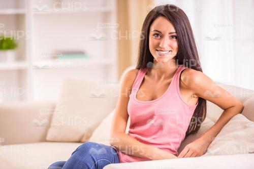 Young Woman At Home Sitting On Sofa Stock Photo