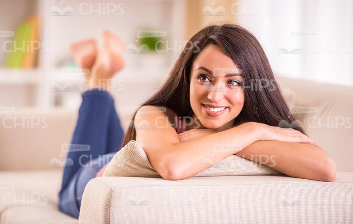 Smiling Woman Lying On Sofa Stock Photo