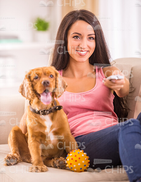 Young Woman And Dog Watching TV Together Stock Photo