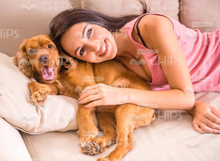 Woman Lying With Puppy And Hugging It Stock Photo