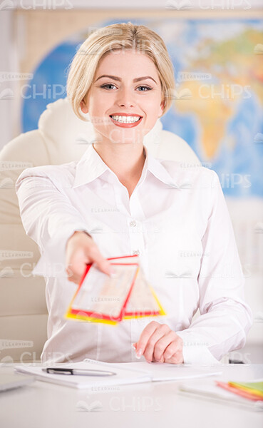 Smiling Female Manager Holding Tickets With Her Outstretched Hand Stock Photo