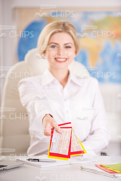 Woman Holding Tickets While Giving Them To Client Stock Photo