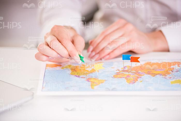 Woman's Hands Putting Little Flags On Map Stock Photo