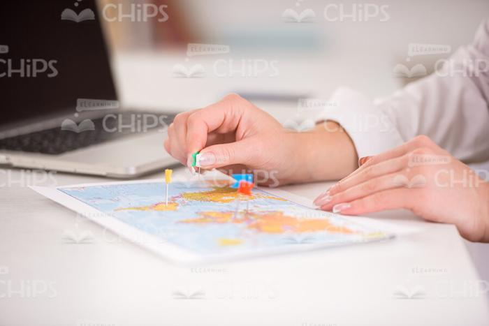 Woman's Hands Using Little Flags To Mark The Places On Map Stock Photo