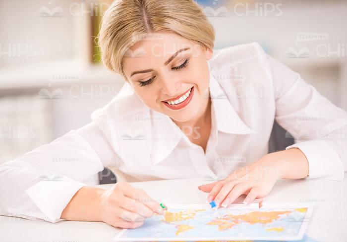 Smiling Woman With Little Flag Marks The Location On Map Stock Photo