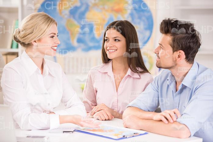 Couple Of Clients Talk With Travel Agency Manager Stock Photo