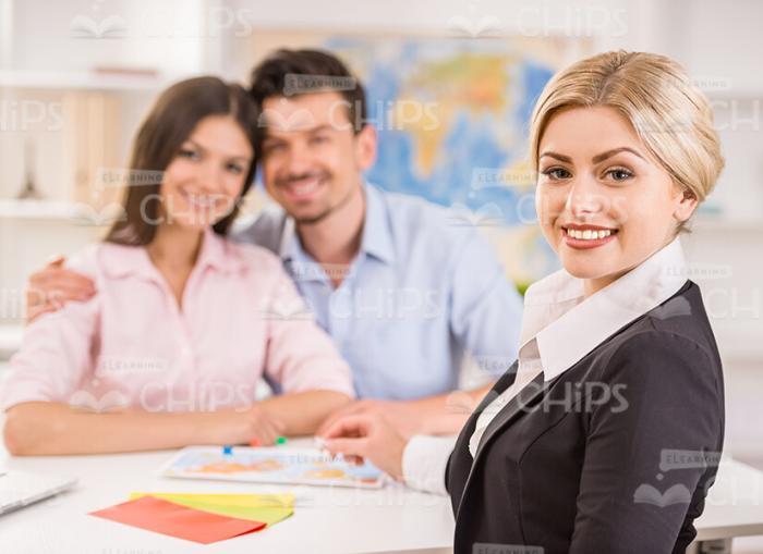 Young Travel Agency Manager With Clients Stock Photo