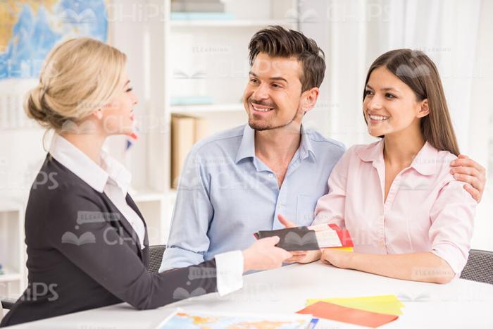Happy Clients With Female Travel Agent Stock Photo
