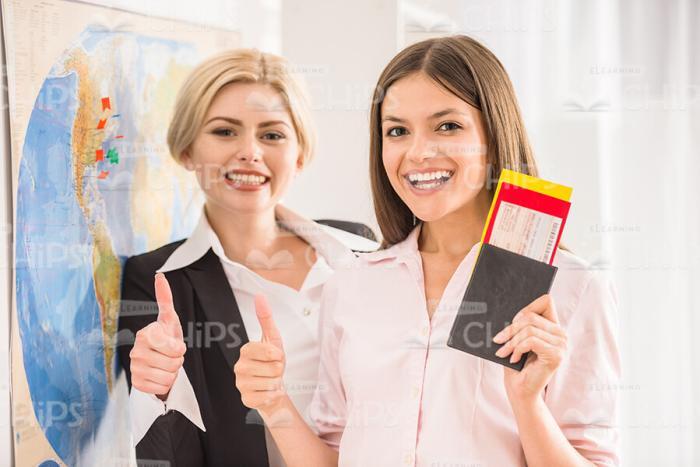 Young Woman And Travel Agency Manager Standing Next To World Map Stock Photo