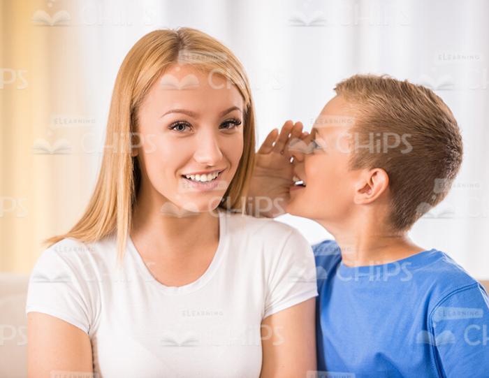 Little Boy Whispering Something To Mother Stock Photo