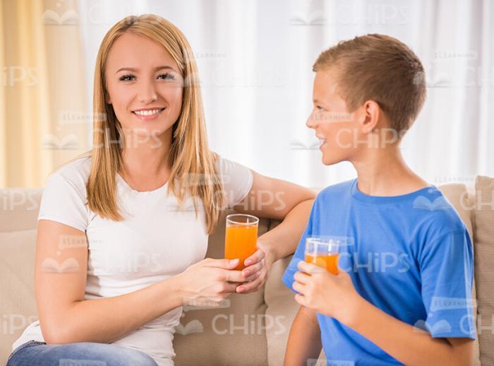 Young Woman With Son Drinking Juice Stock Photo