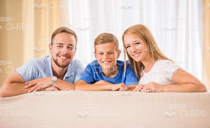 Happy Family Behind The Sofa Stock Photo