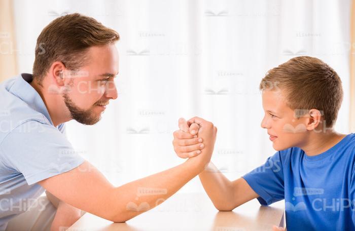 Young Family Playing Arm Wrestling Stock Photo