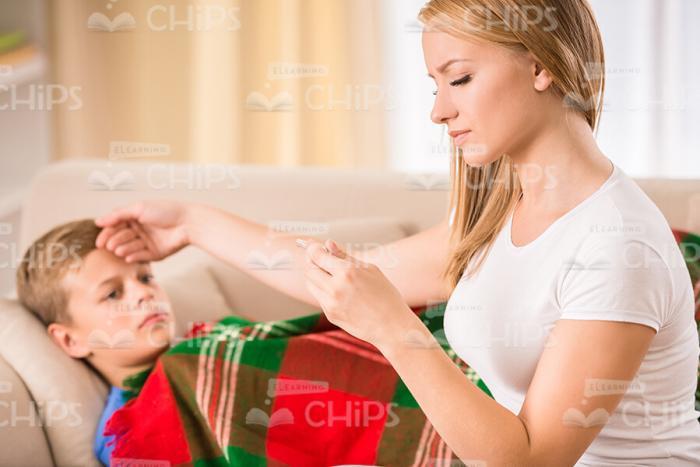 Ill Young Boy With Mother At Home Stock Photo