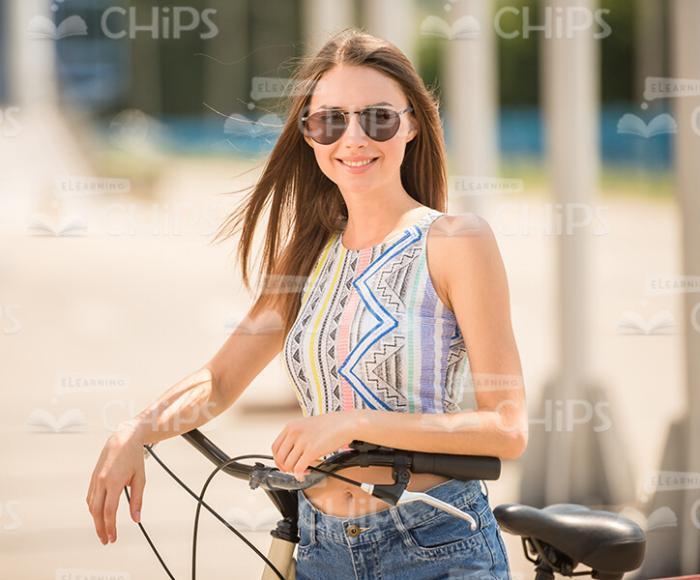 Woman Wearing Glasses And Holding Bicycle Stock Photo