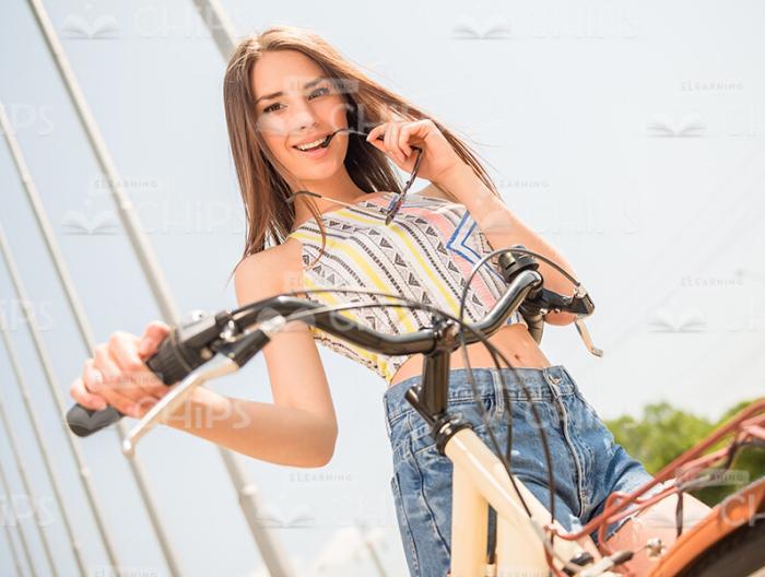 Woman Holding Bicycle And Wearing Sunglasses Stock Photo