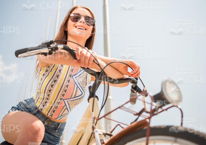 Pretty Woman Leaning On Bike Handlebars Stock Photo