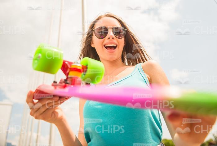 Discouraged Woman Holding Skateboard Stock Photo
