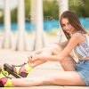 Female Roller-Skater Resting On Ground Stock Photo