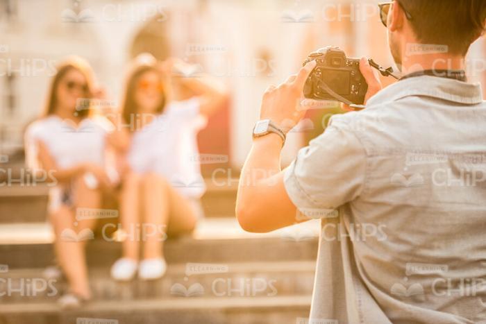 Man Holding Camera And Taking Picture Of His Friends Stock Photo