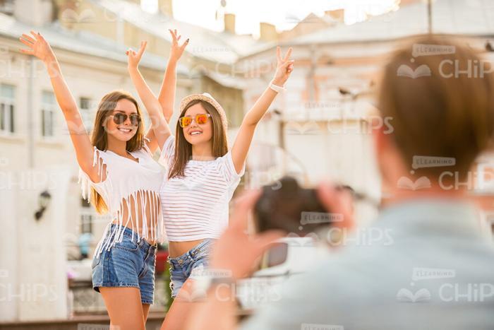 Pretty Girls Raising Hands Up While Posing For Camera Stock Photo