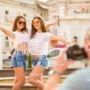 Pretty Girls Throwing Hands Up And Posing For Camera Stock Photo