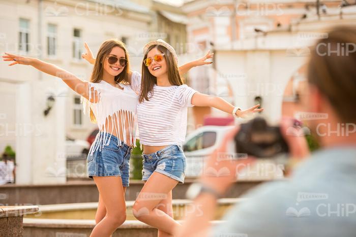 Pretty Girls Throwing Hands Up And Posing For Camera Stock Photo