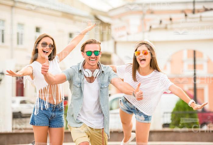 Happy Young Man Showing His Thumbs Up While Having Fun With Girls Stock Photo