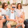 Young People Sitting On Stairs And Using Tablet Stock Photo