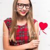 Cheerful Young Girl Holding Little Heart Stock Photo
