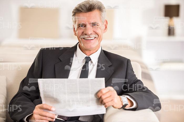 Aged Businessman With Newspaper Stock Photo