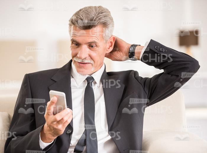 Discouraged Middle Aged Man Using Mobile Phone Stock Photo