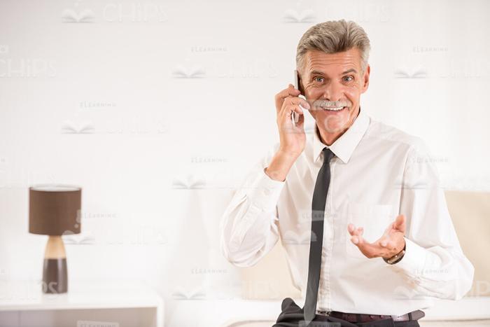 Aged Businessman Holding Phone Conversation Stock Photo