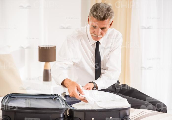 Mid-Aged Businessman Packing His Bag Stock Photo