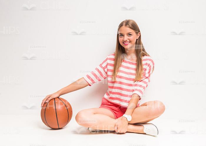 Smiling Teenage Girl Sitting With Basketball Stock Photo