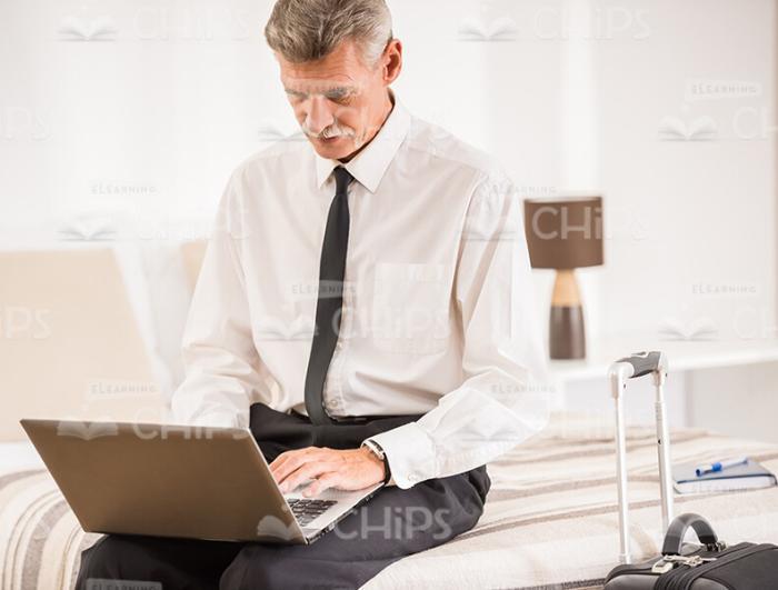 Attentive Aged Businessman With Laptop Stock Photo