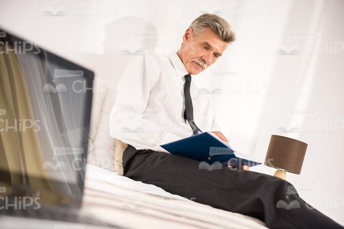 Aged Businessman In Hotel Room Stock Photo