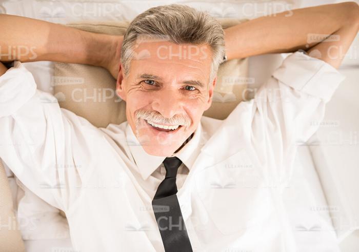 Happy Man Lying In Bed Stock Photo
