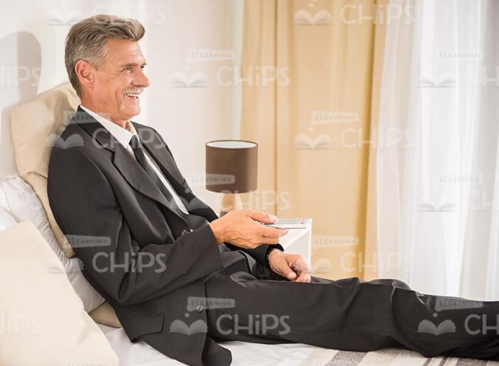 Mid-Aged Businessman Resting On Bed Stock Photo