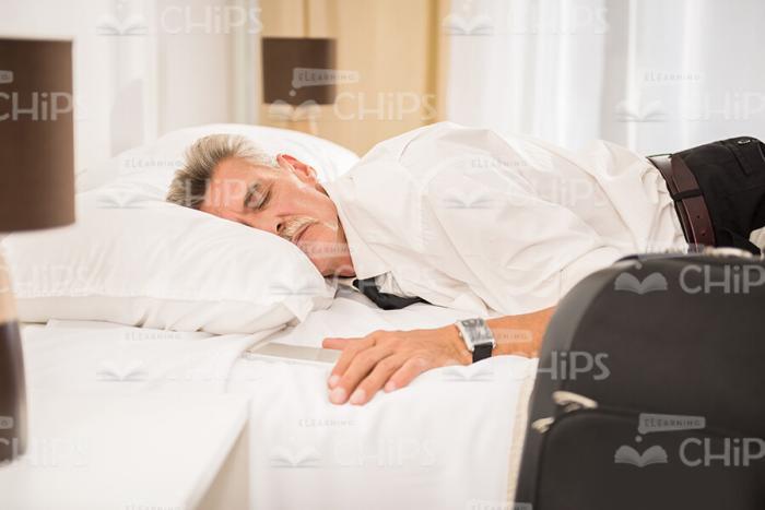 Aged Businessman Sleeping In Bed Stock Photo
