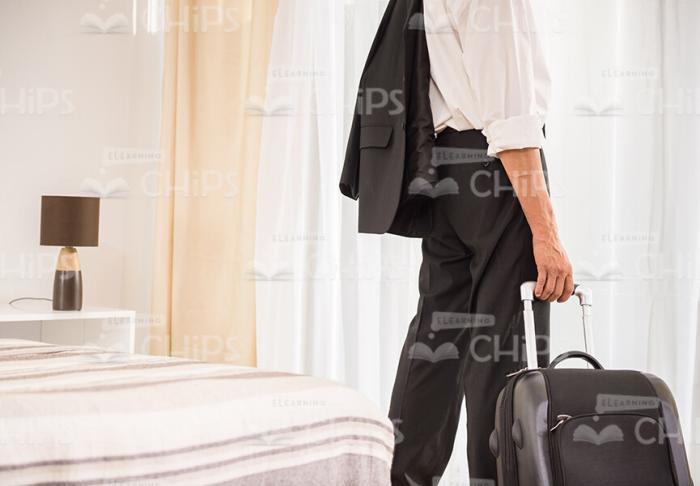 Man Holding Suitcase Rear View Stock Photo