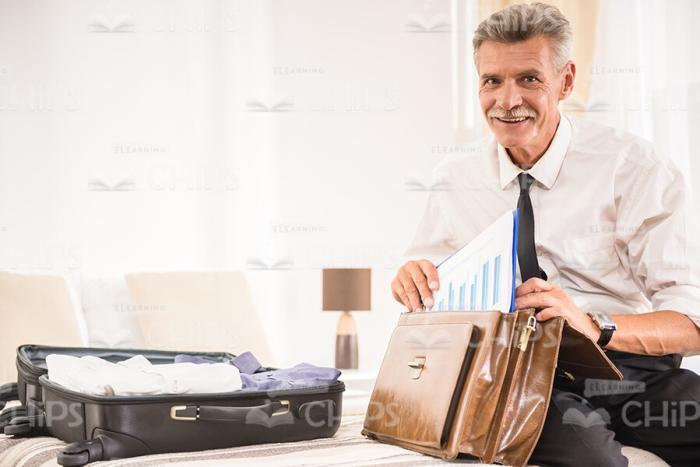 Aged Businessman Packing Briefcase Stock Photo