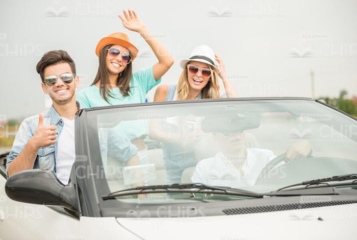 Attractive Friends Driving In Sports Car Stock Photo