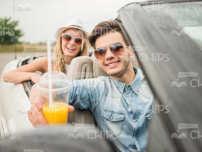 Friends With Juice Sit In Cabriolet Car Stock Photo
