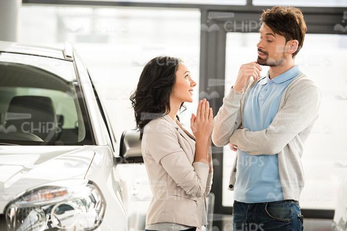Young Woman Tries To Convince Man At Car Dealershop Stock Photo