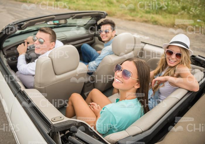 Four Happy Friends Driving Convertible Car Stock Photo