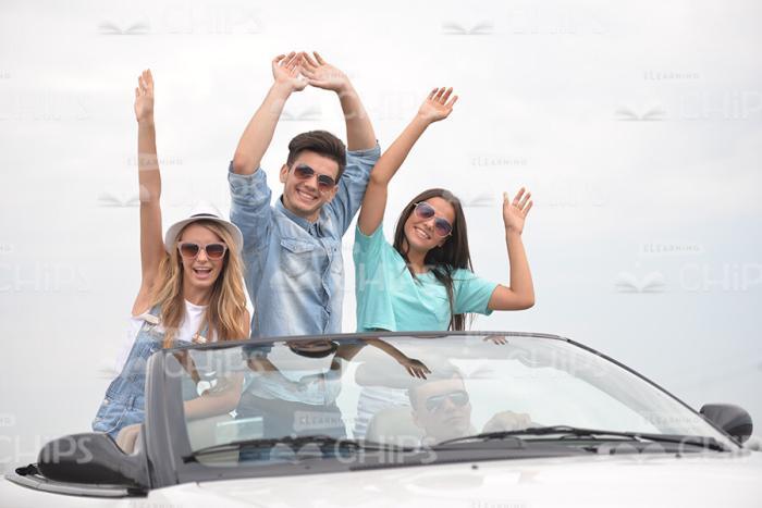 Happy Friends Standing Up And Raising Hands In Cabriolet Car Stock Photo
